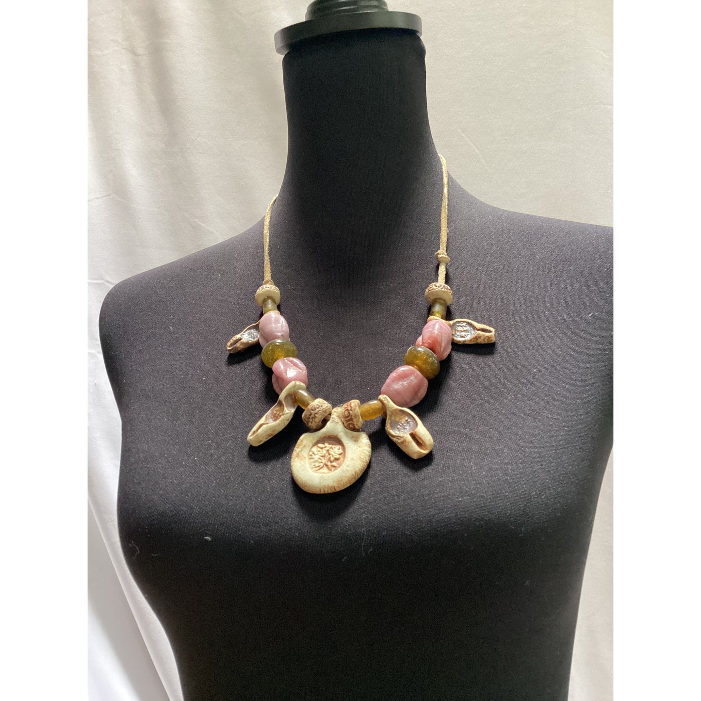 Necklace made of beads and ceramic pieces. Strung on rawhide