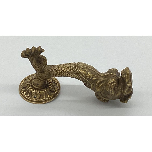 Antique brass door handle with image of a dolphin